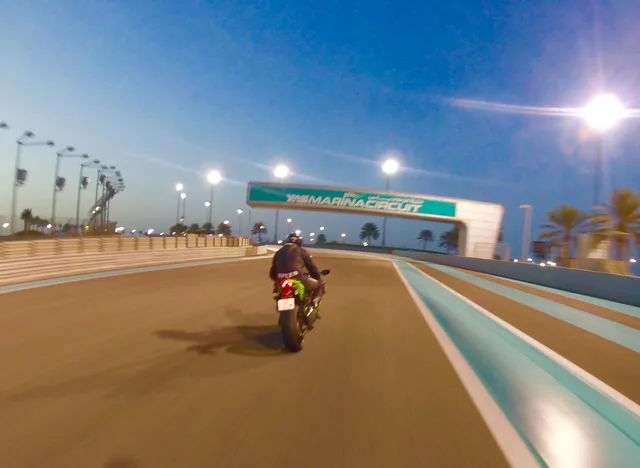 Rider on track under the lights at dusk