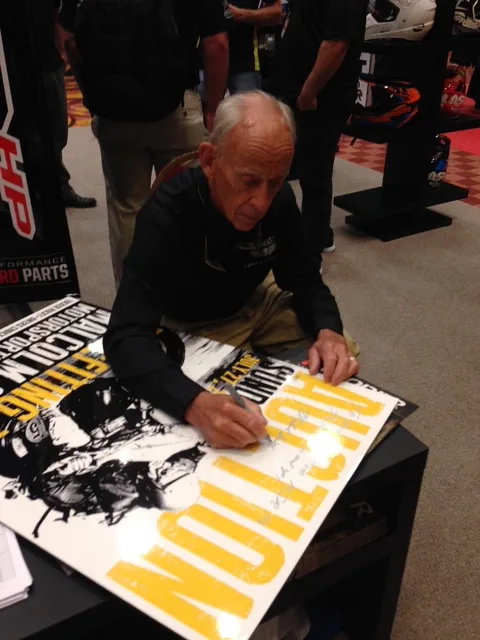 Signing a poster at an industry event